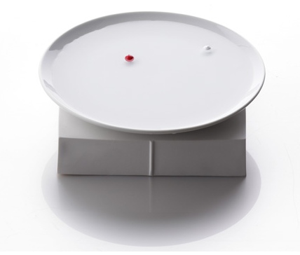 a white plate with small red thing on it
