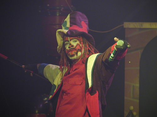 clown with red makeup and yellow face paint on stage