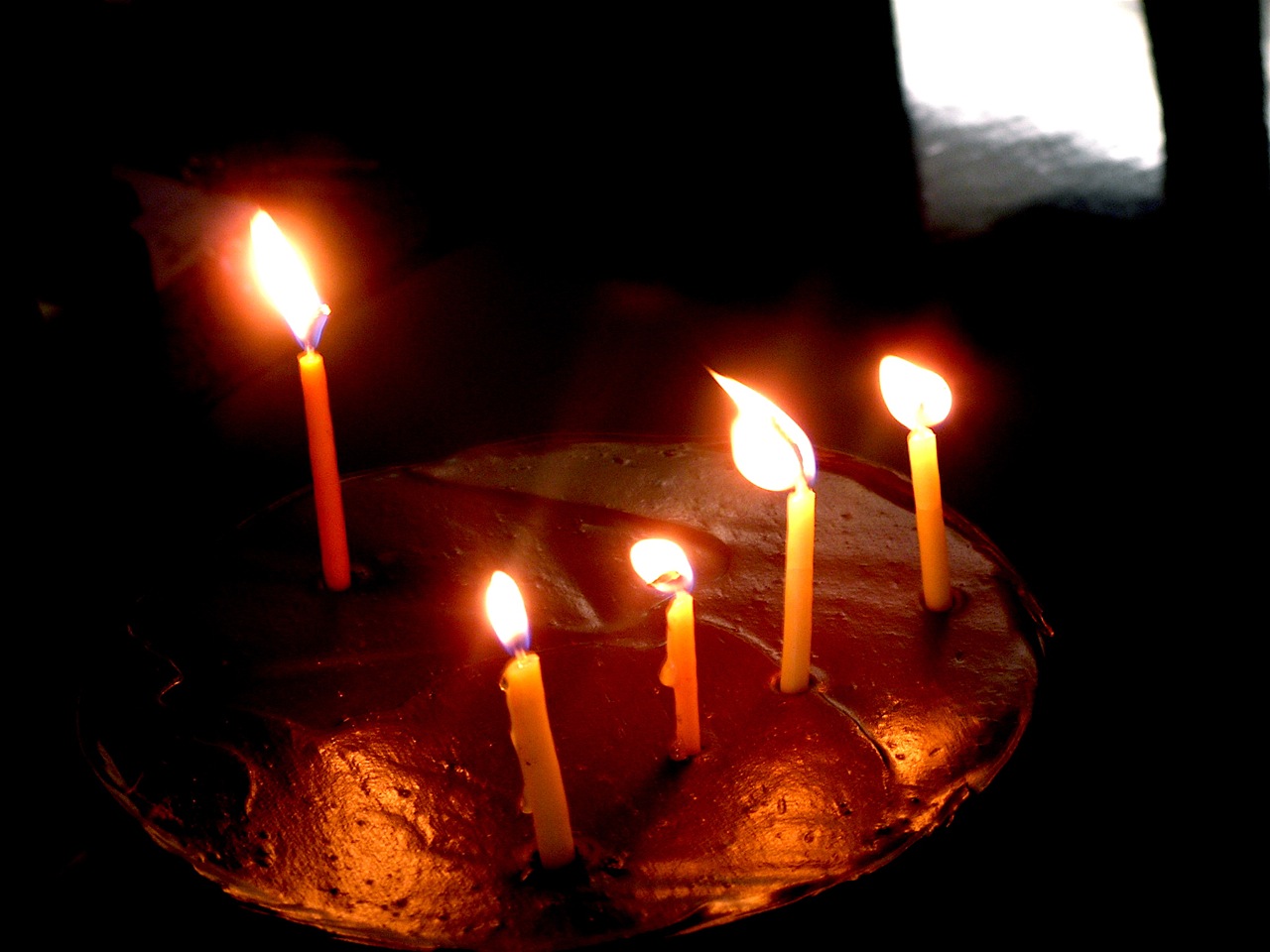 a group of lit candles sit in the middle of a cake