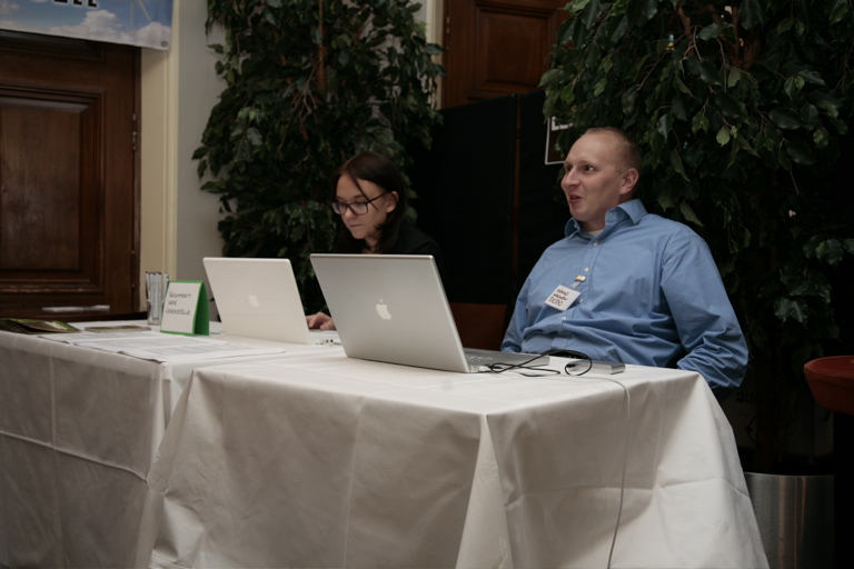 two men are working on laptops at a table