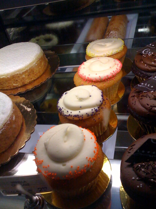many different types of cakes in a glass case