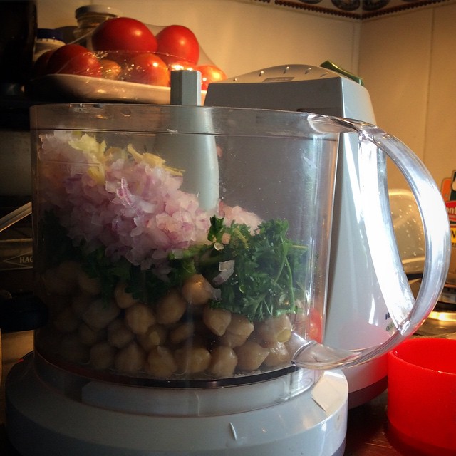 a white food processor with a bowl of food in front of it