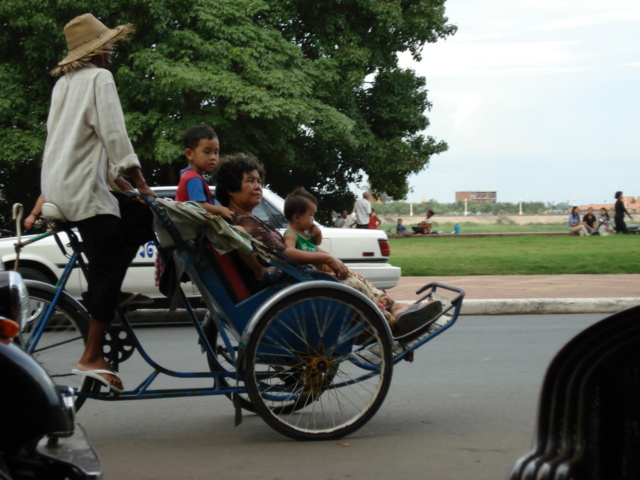 a woman is standing over a group of children riding in a carriage