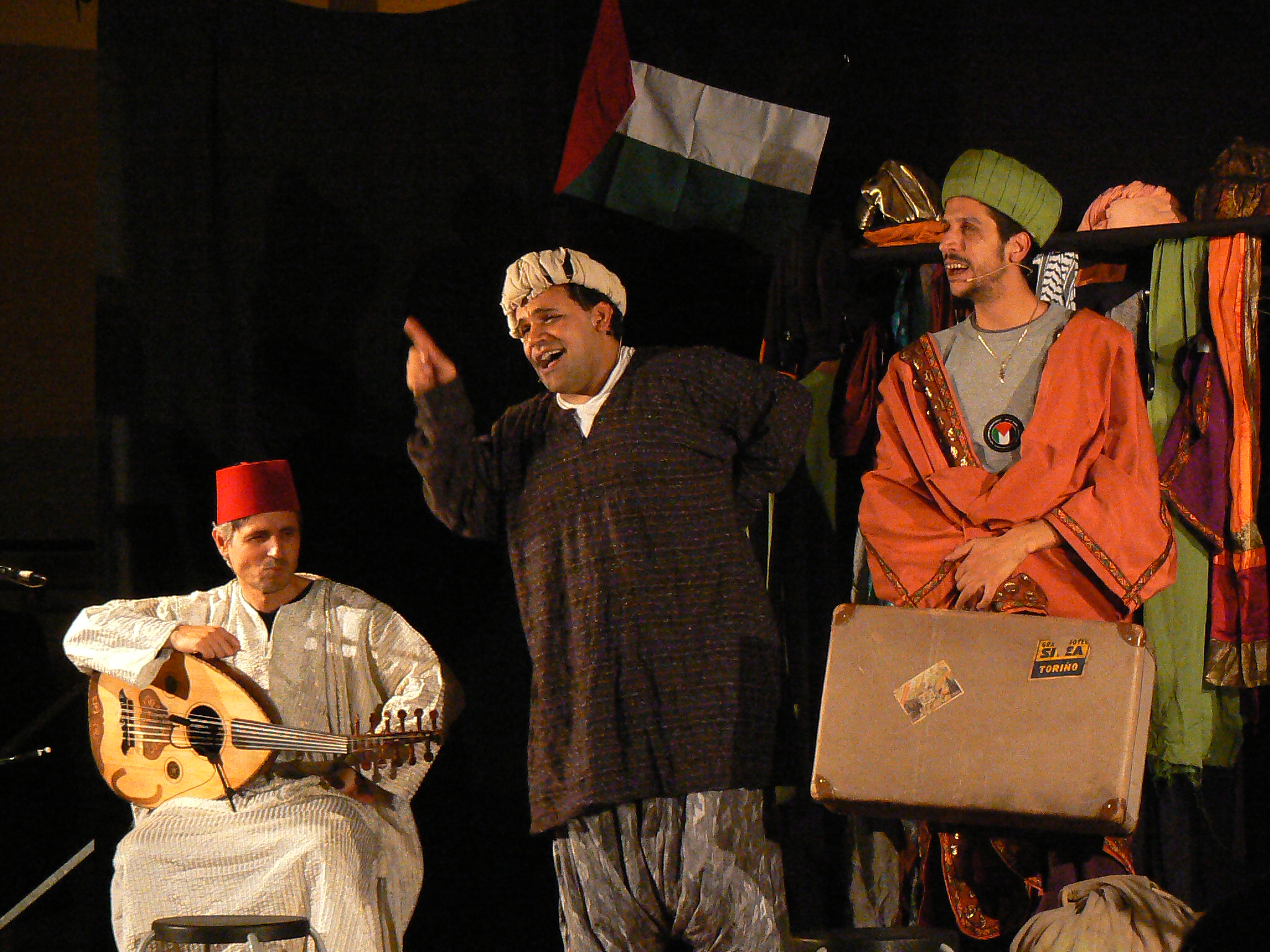 men with various attire stand around in a stage