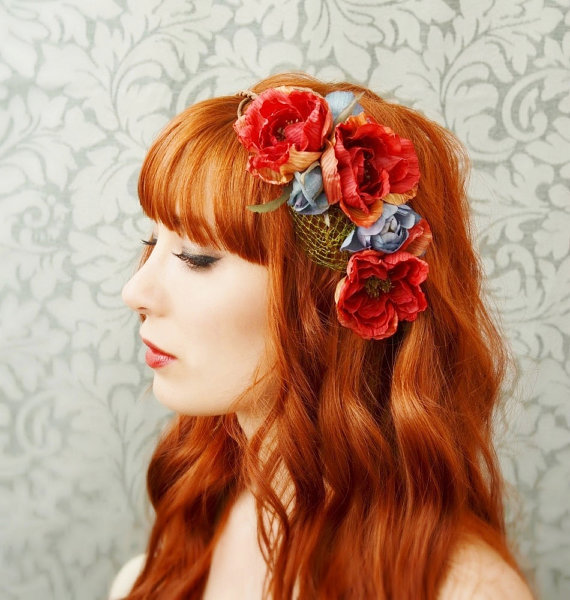the beautiful redhead haired girl has flowers in her hair
