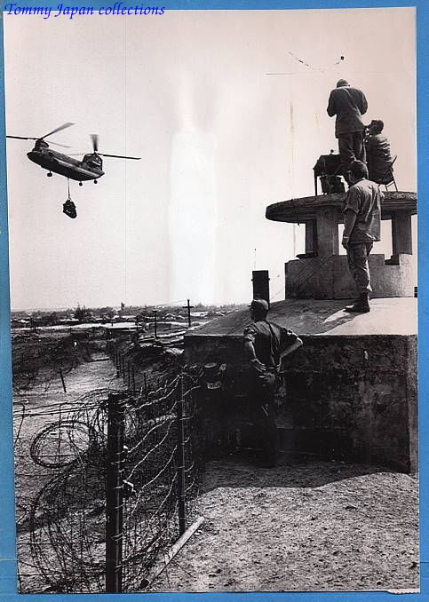 an old picture of a man watching a military helicopter