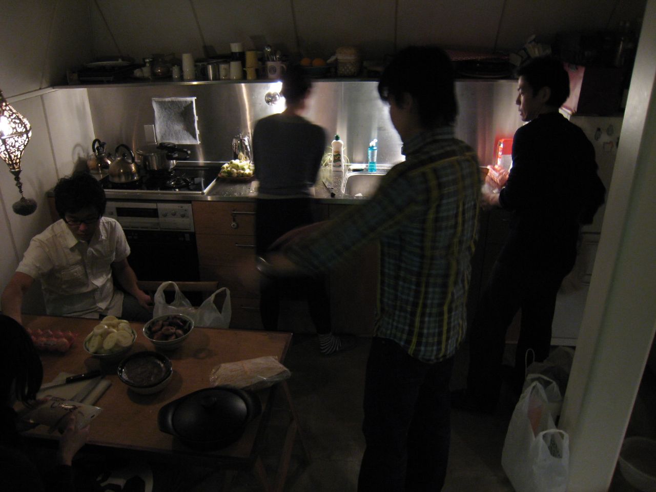 a kitchen scene with focus on a young man preparing food