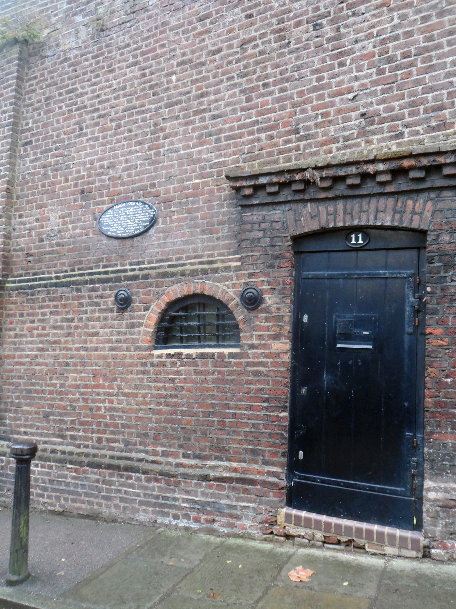 the side of an old brick building with black door