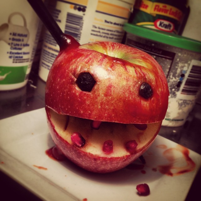 an apple with teeth and a toothbrush sticking out