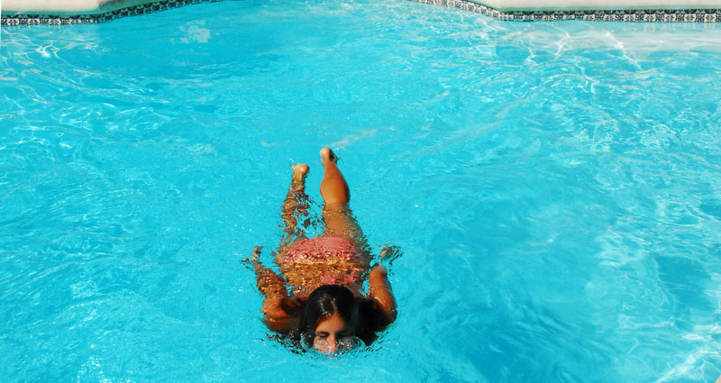a woman is swimming in a swimming pool