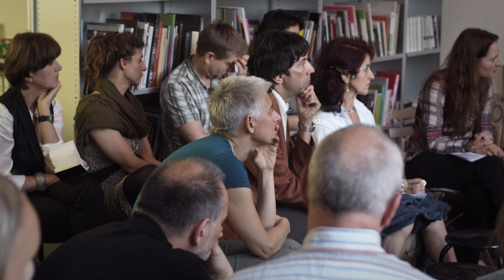 a group of people sitting around each other in a room