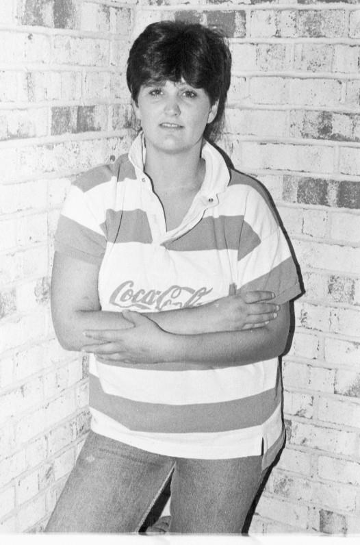 a female tennis player standing with her arms folded