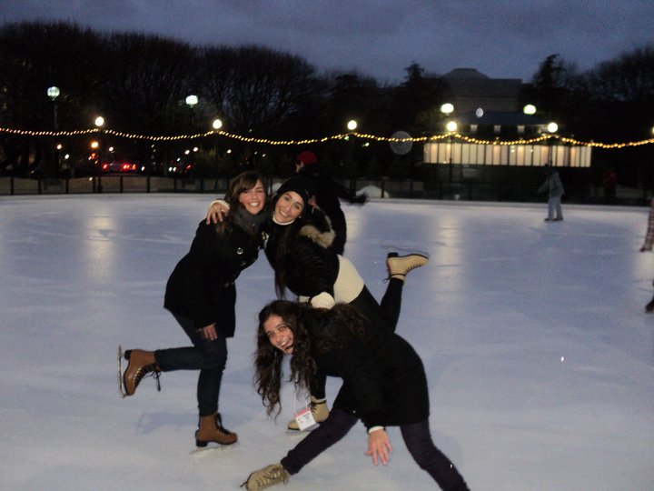 four girls playing on an ice rink in the evening