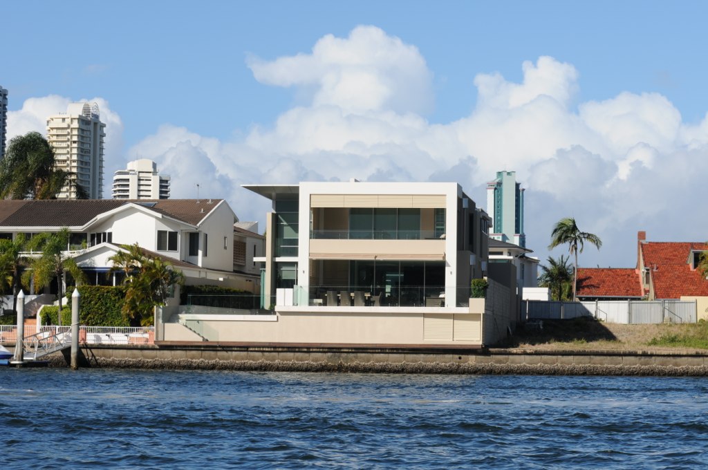 a house sitting next to the ocean and on some piers