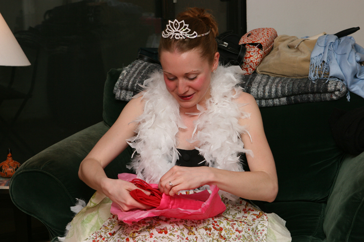 a woman is sitting on a green couch holding a pink bag