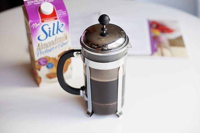 a silver and black coffee pot and some cereal