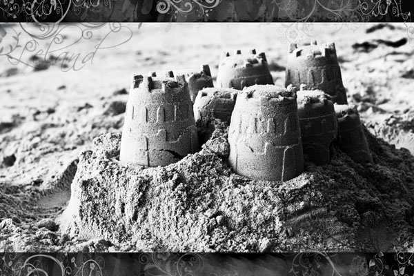 a sand castle sitting in the sand on top of a beach