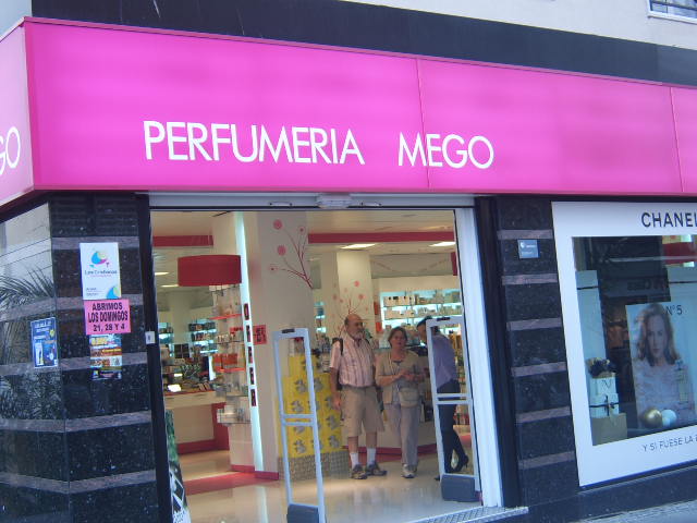 three women are walking in front of a cosmetics store