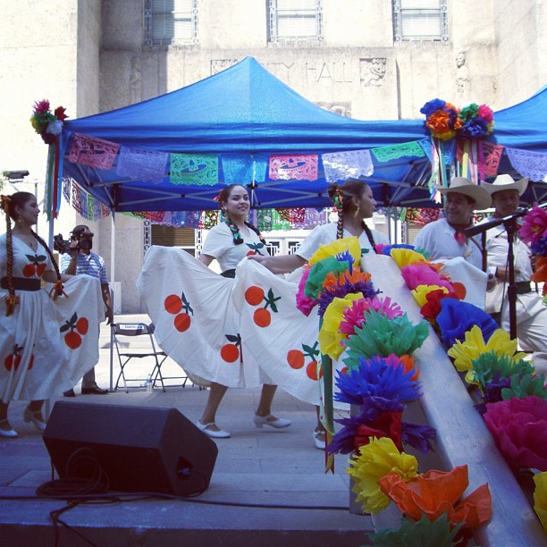 the women in dresses are dancing near the tent