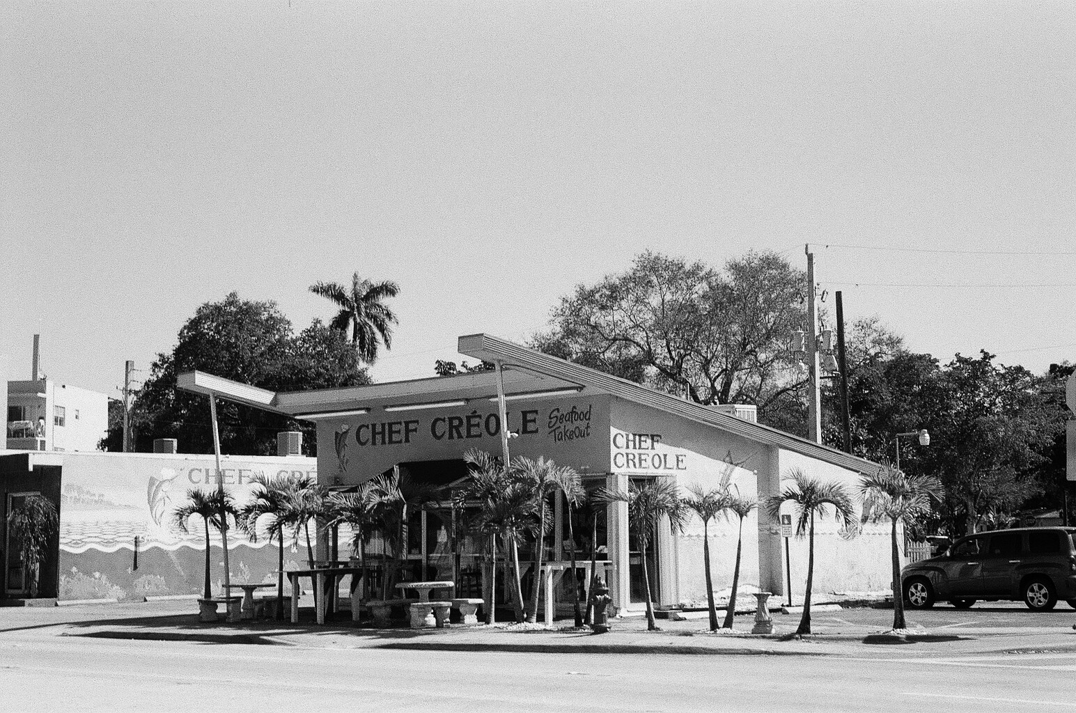 an old gas station with a car parked in front