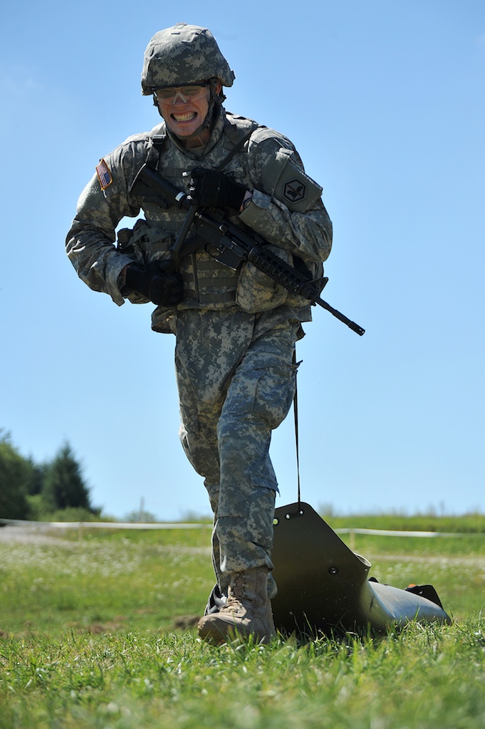 a soldier holding an automatic rifle and walking with a duck