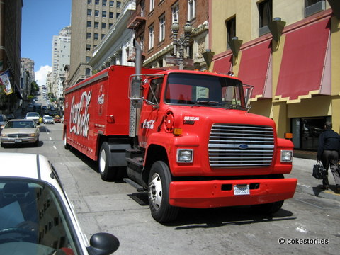 a red truck is on the street during the day