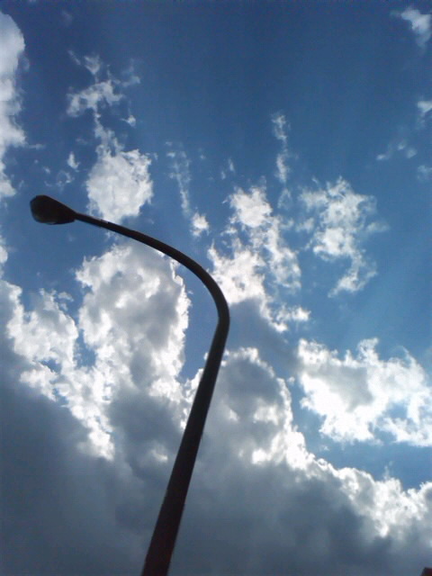 a street light with white clouds behind it