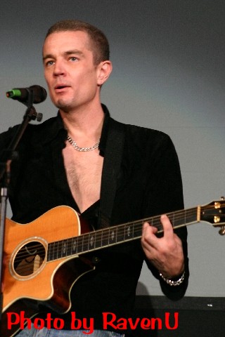 a man standing on a stage with a guitar