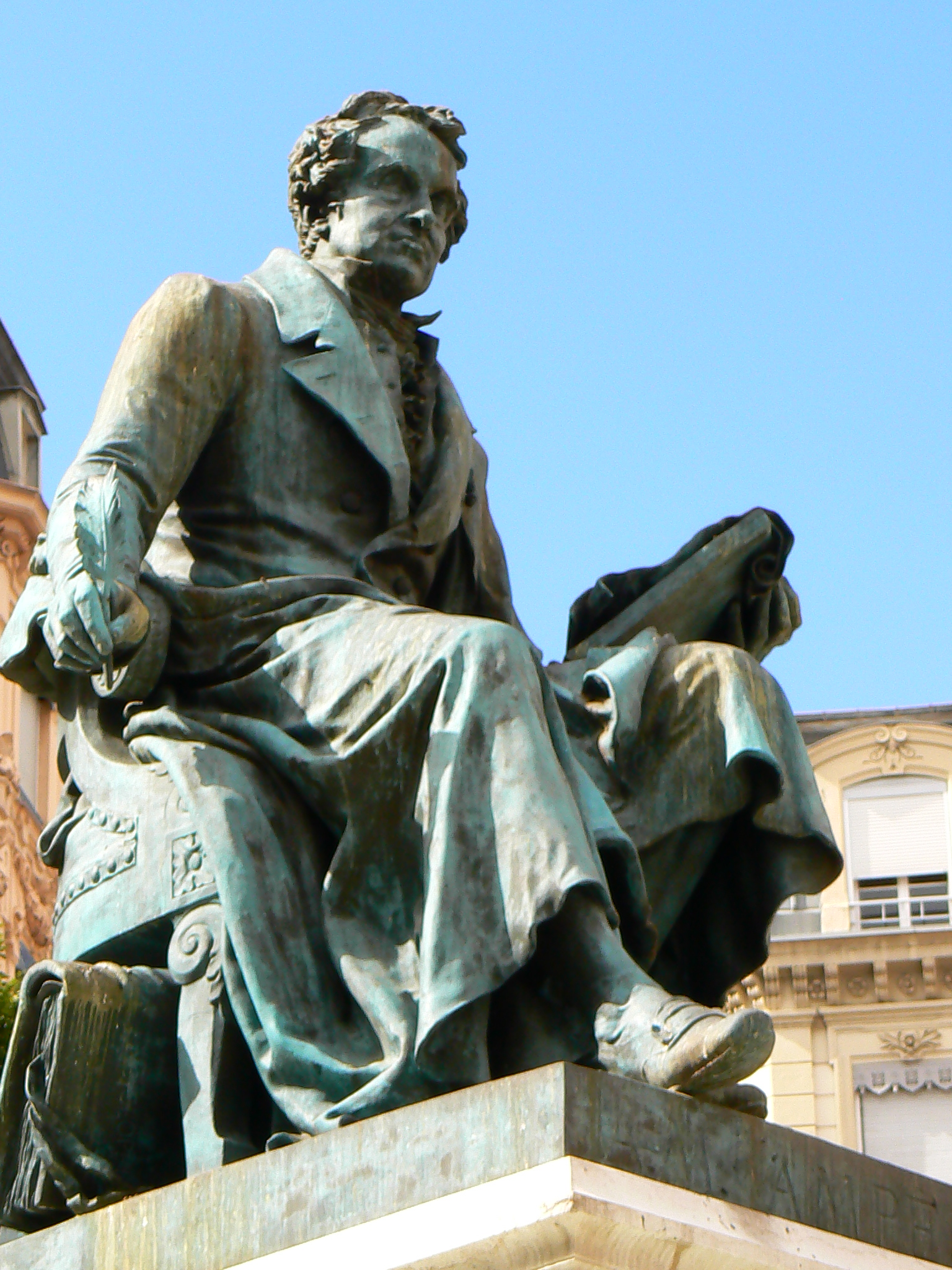 a statue of a man sitting next to a building