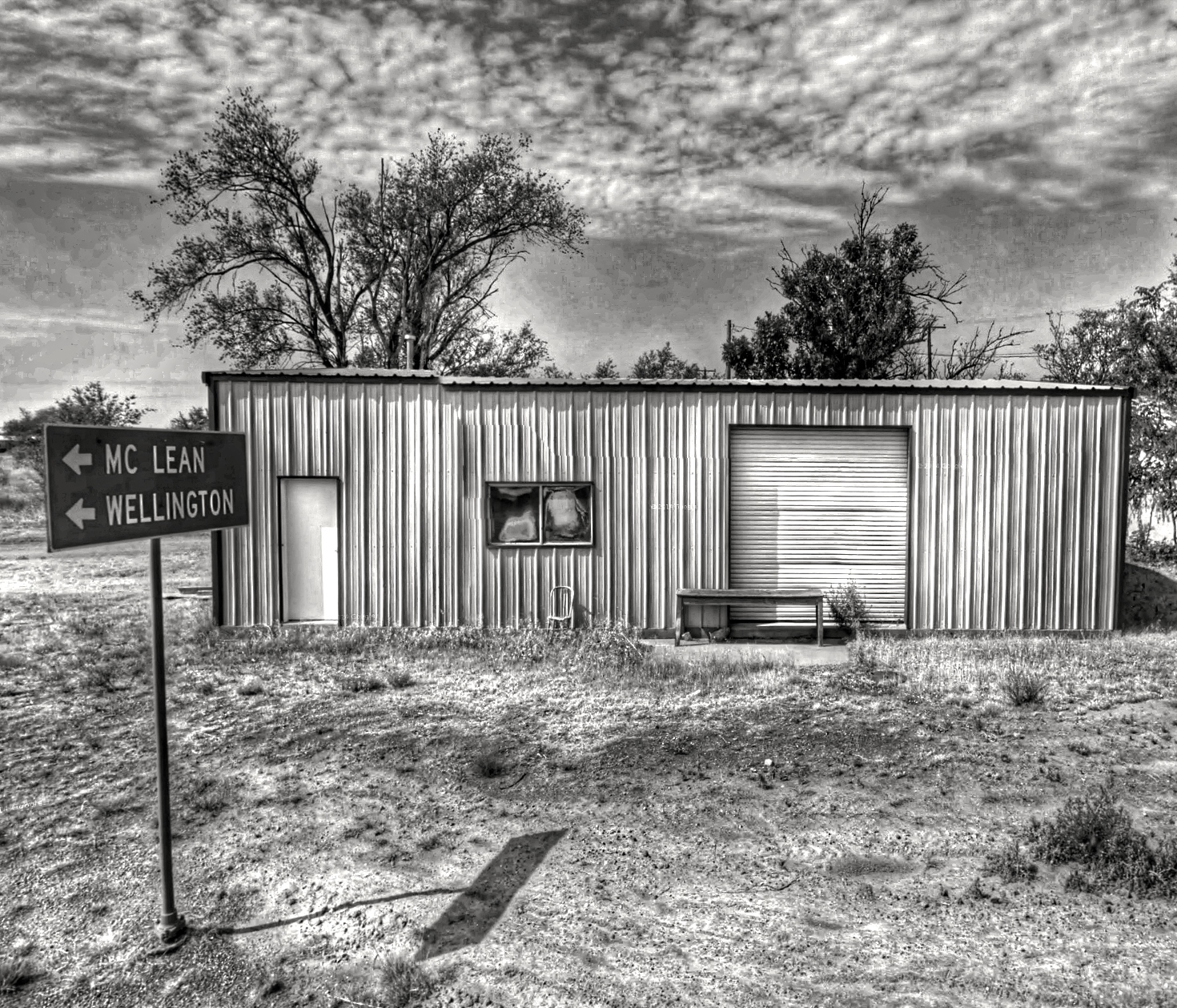 a shack with two motorcycles parked next to a street sign