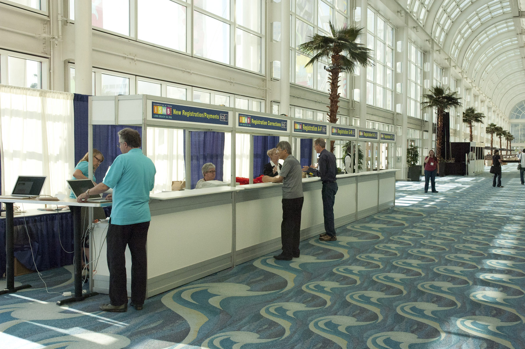 two men standing at a counter in an airport terminal