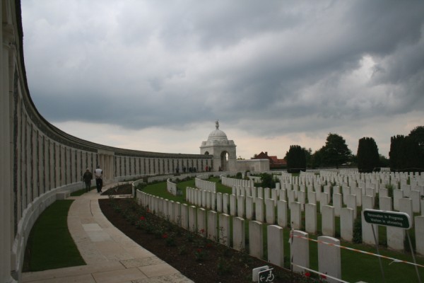 the fence and graves of world war two and people walking near it
