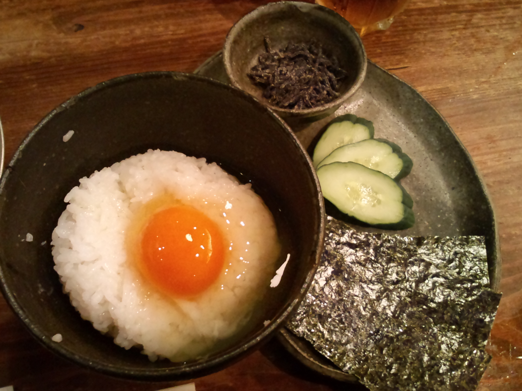 an egg is fried in a pan with cucumber slices