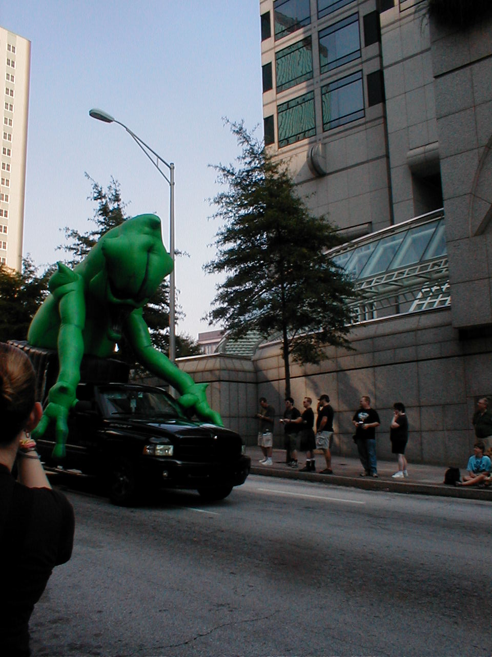 large green giant creature on a car in the road