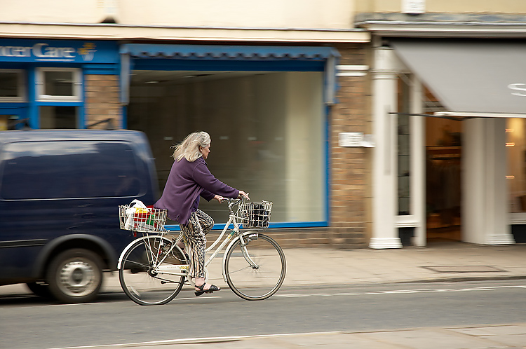 the older person is riding his bicycle down the street