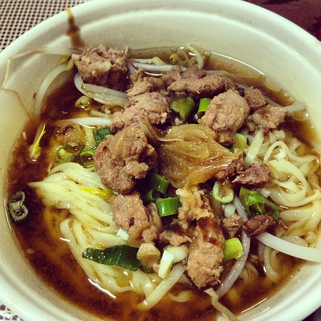 a bowl full of noodles with meat and vegetables