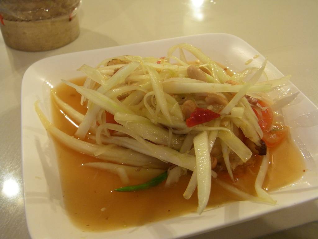 a white plate topped with salad covered in sauce