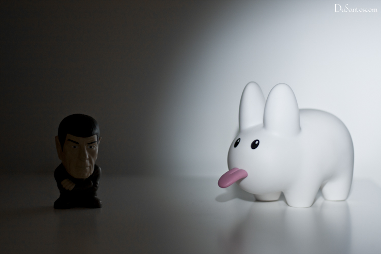 a toy bunny with its tongue out next to an odd looking ceramic head