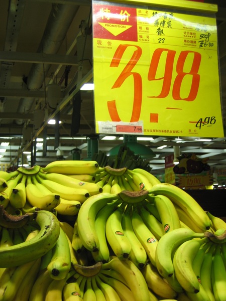 banana stand at a grocery store with an ad for the number 3290