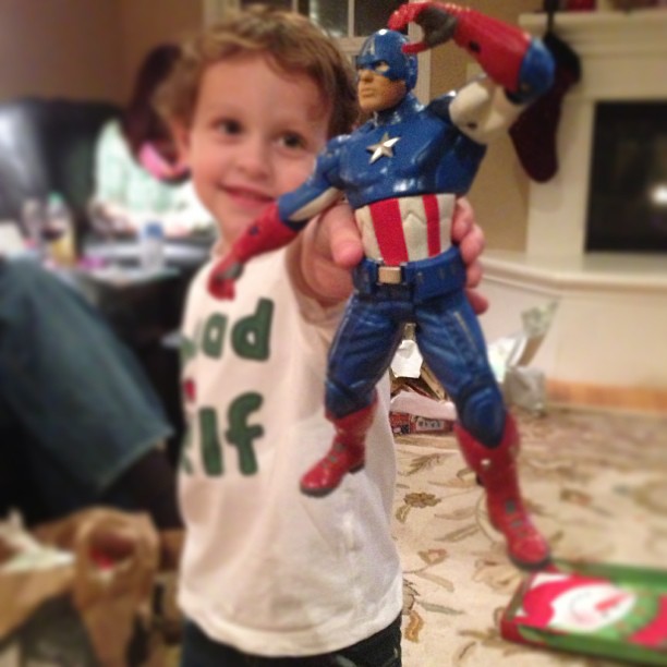 a little boy in the middle of being silly about his avengers toy