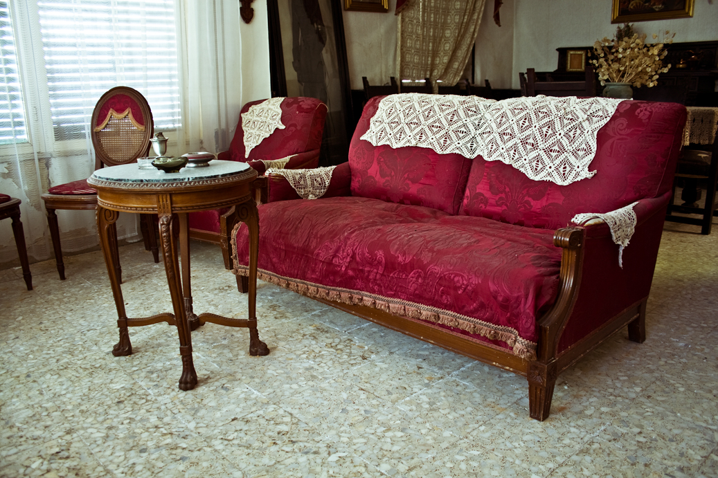 this living room has red couches and antique furniture