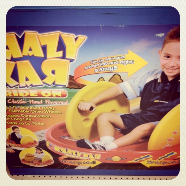 the boy is having fun on the yellow toy car