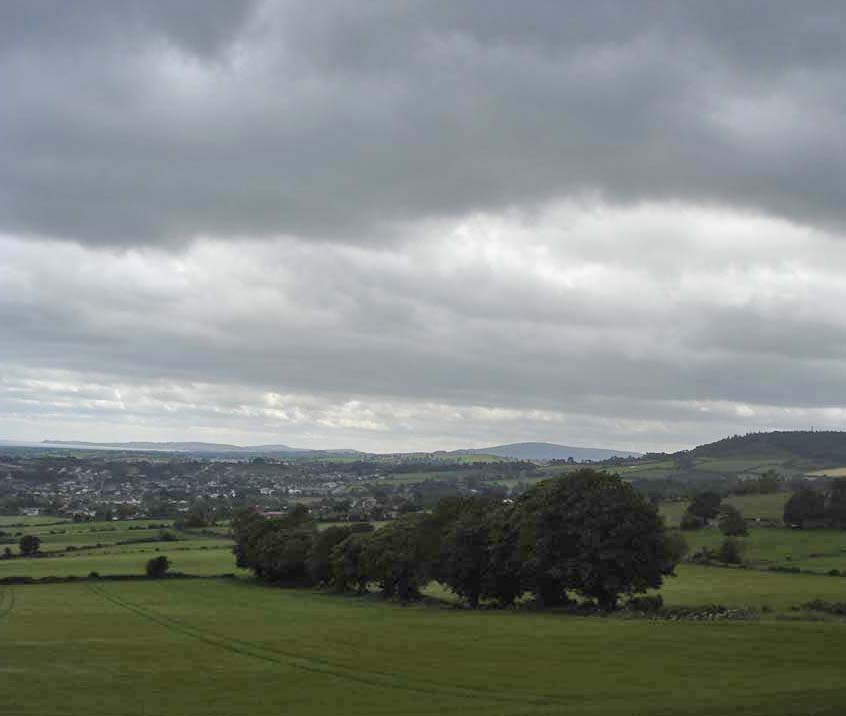 view of countryside with dark clouds and lots of grass