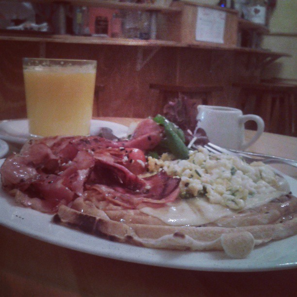 the plate of food is next to a cup of orange juice