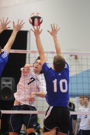 a group of young people play a game of volleyball