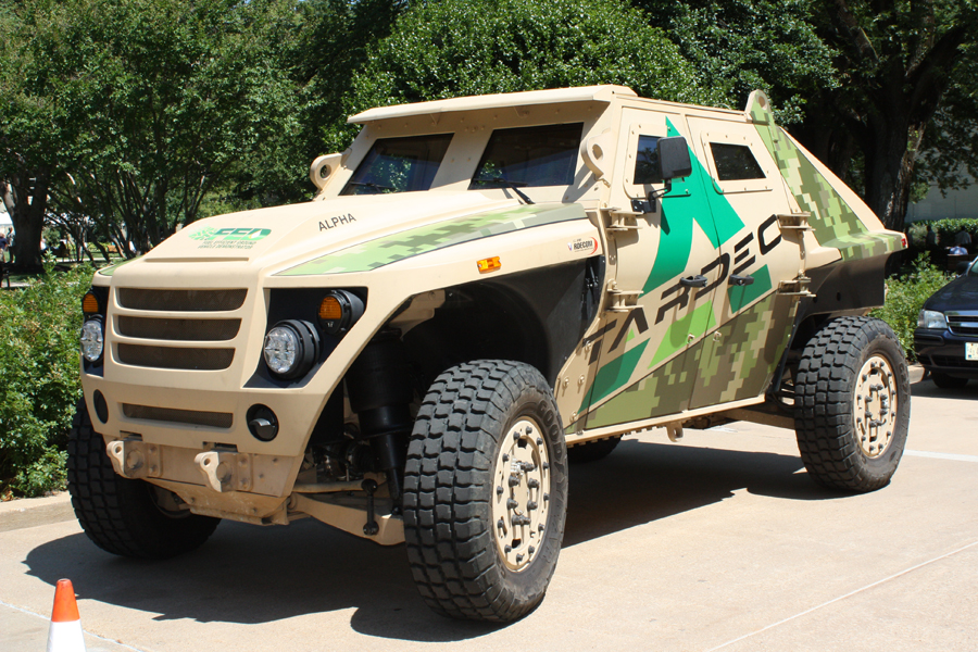 an army vehicle with camouflaged paint parked on the street