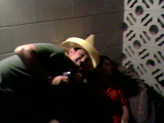 two people posing with hats on in the dark