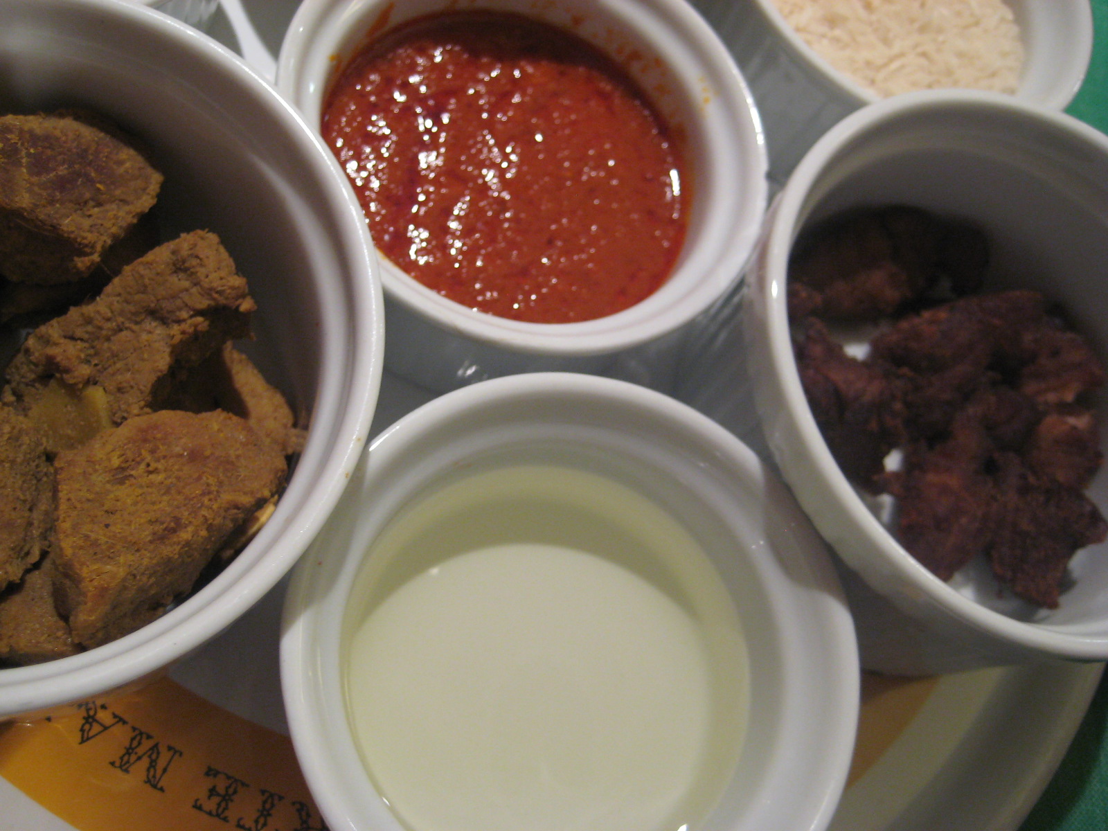 several small bowls filled with different ingredients on top of a plate