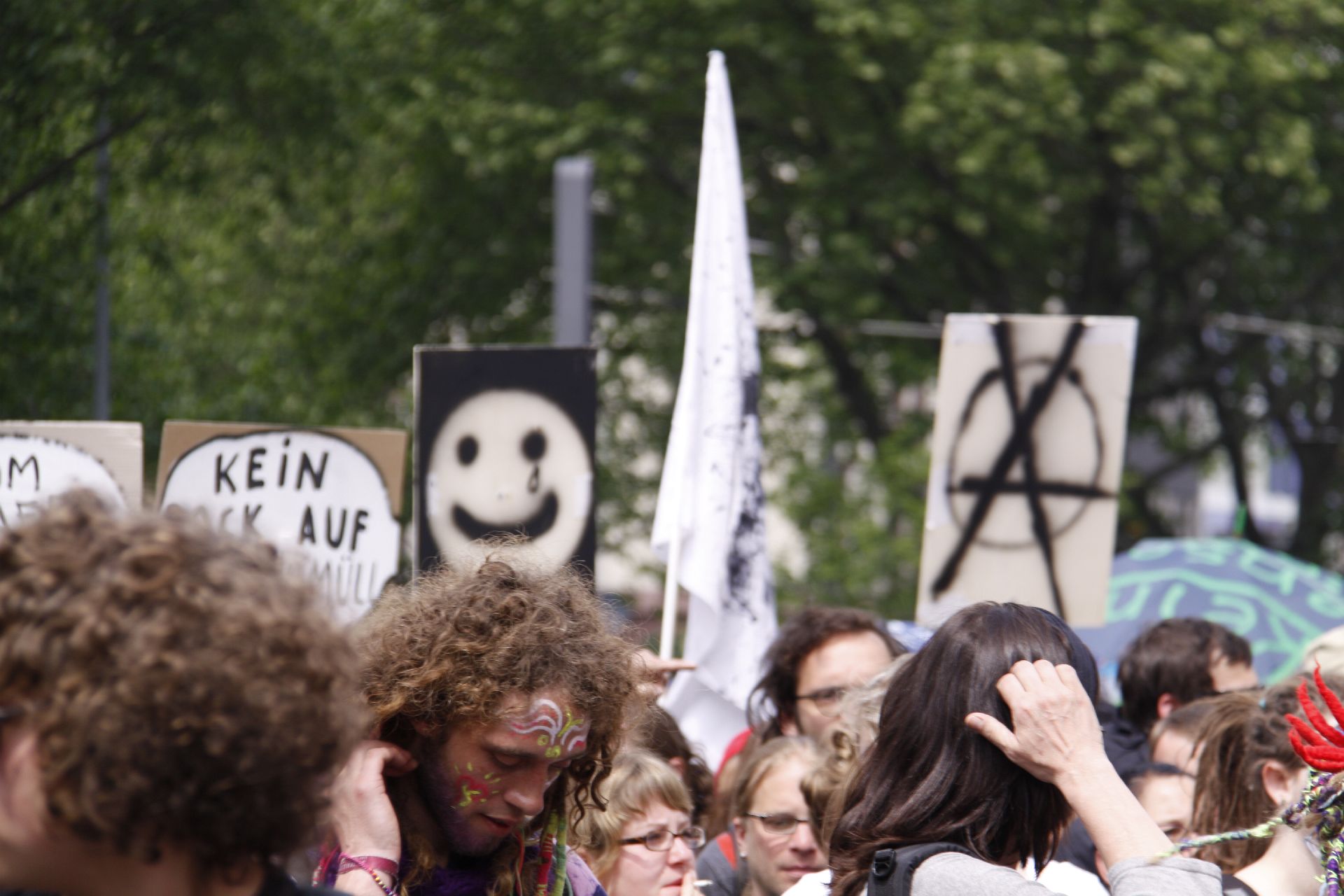 a crowd holds up signs at a political rally