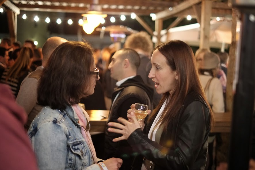 two woman talking in a crowded bar